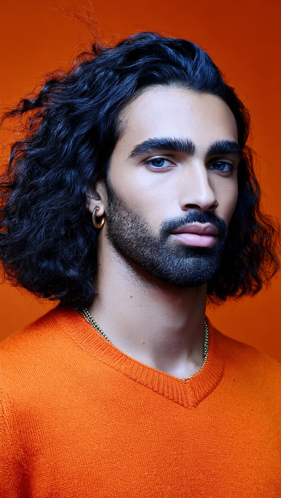 Cinematic masculine character: AI-generated man with long dark curly hair, beard, gold chain, hoop earring, and an orange crew-neck sweater against a warm orange background